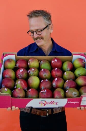 Rick holding box of mangoes
