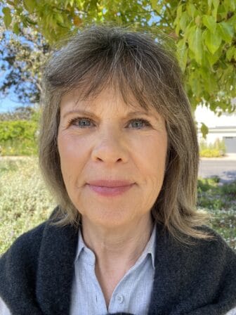Pam Kaiser smiling in front of tree