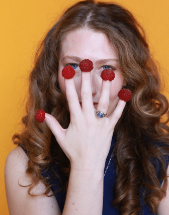 Caitlin with raspberries on her fingers