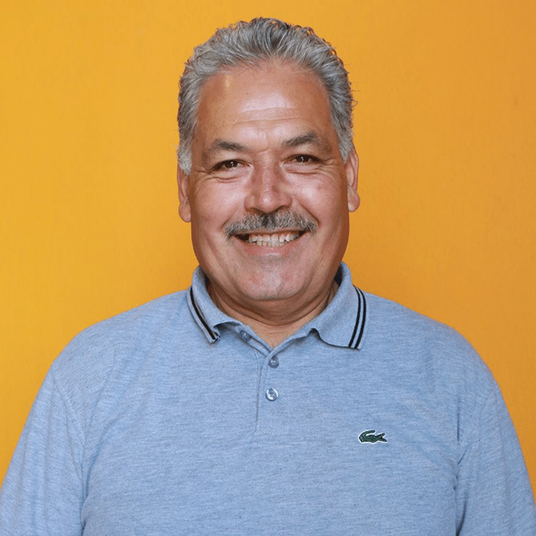 Victor smiling in front of orange background