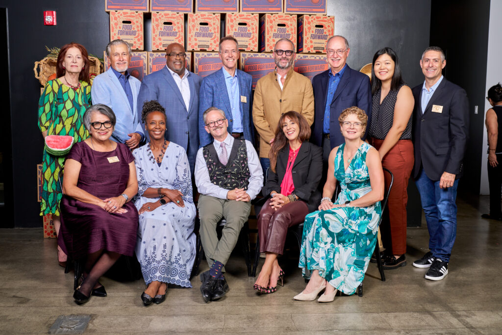 group photo in front of stacked food forward produce boxes at the tomorrow’s table event.